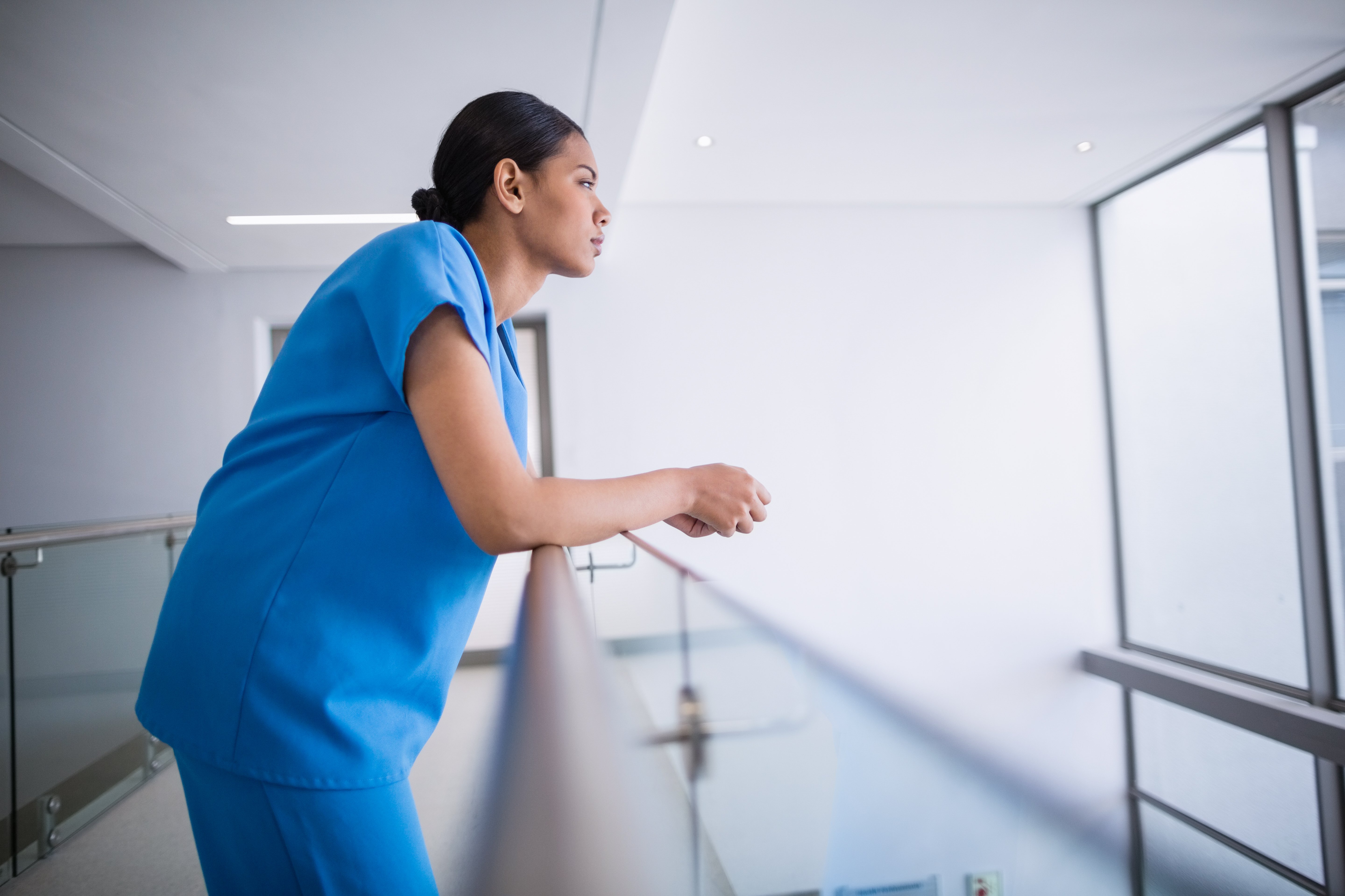 thoughtful-nurse-leaning-on-railing-2021-08-28-16-45-17-utc